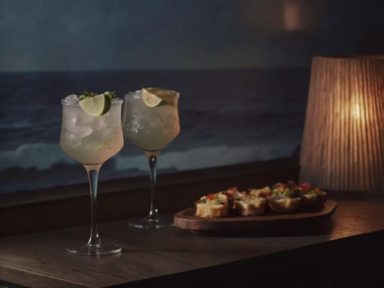 Tropical cocktails with lime garnish and appetizers at a Costa Rican beachside restaurant