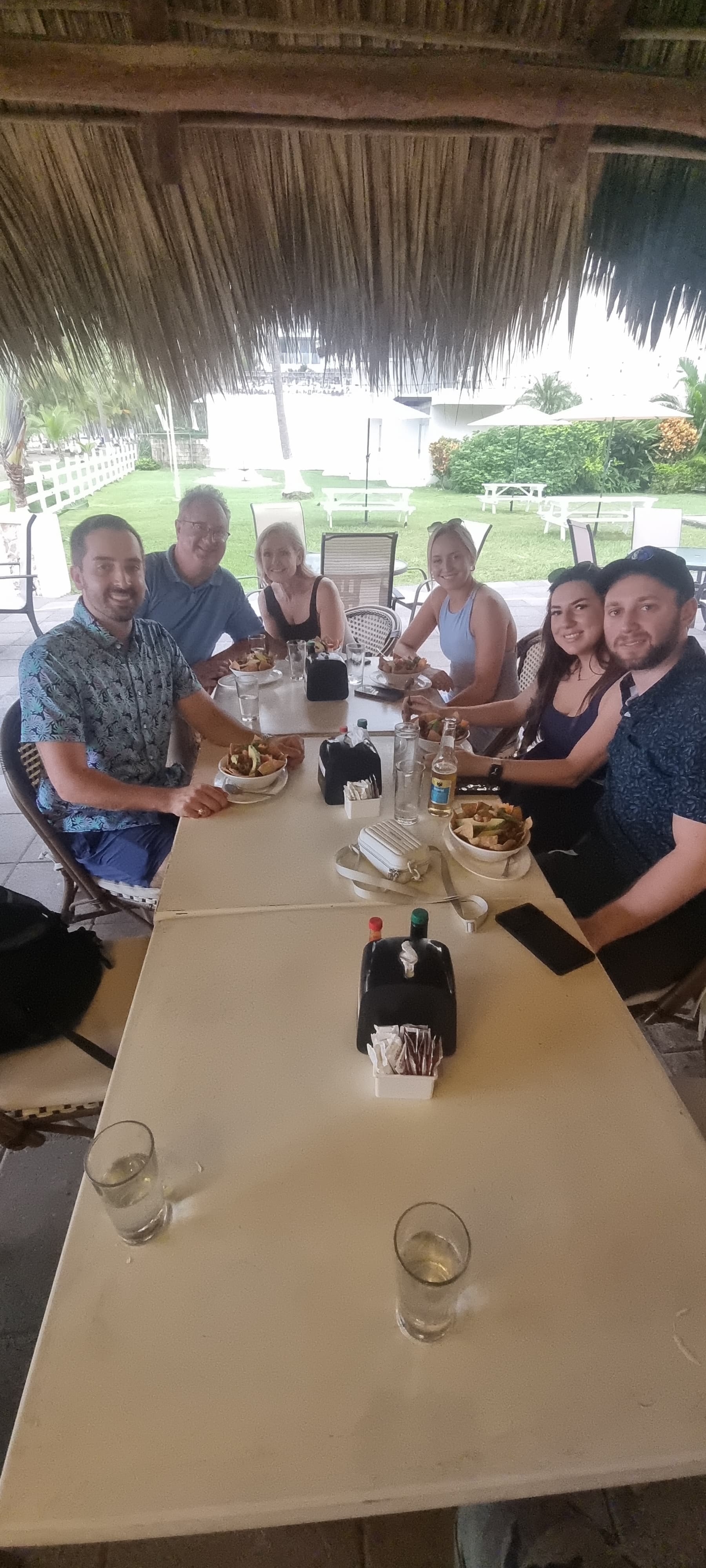 Tour group of six dining together at a palapa beachfront restaurant in Jaco